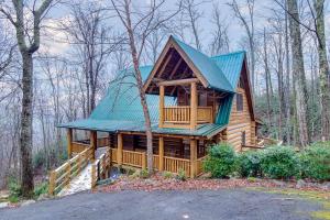 a large wooden cabin in the woods with a green roof at #3685 Brookside in Hatchertown