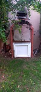 een oud bakstenen gebouw met een witte deur in het gras bij Villa à louer dans un endroit magnifique in Tifnit