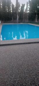 a blue swimming pool with a bench in the background at Villa à louer dans un endroit magnifique in Tifnit