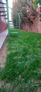 a green park bench sitting in the grass at Villa à louer dans un endroit magnifique in Tifnit
