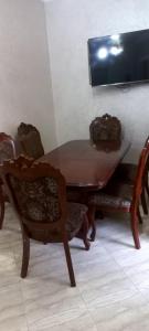 un tavolo e sedie in legno con una televisione appesa a un muro di Villa à louer dans un endroit magnifique a Tifnit