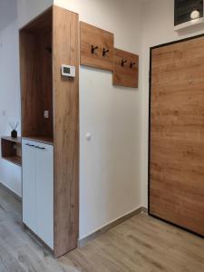 a kitchen with a refrigerator and a wooden door at Apartman Maslacak in Divčibare