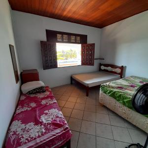 a room with two beds and a window at Casas e kitnetes em Praia de Guaibim in São Fidélis