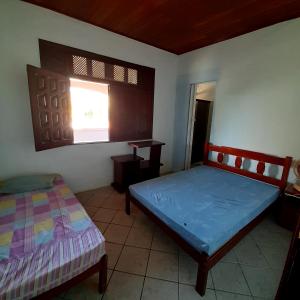 a bedroom with two beds and a window at Casas e kitnetes em Praia de Guaibim in São Fidélis