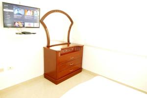 een kamer met een houten dressoir en een televisie bij Condominio Charito Suite 2G a 12 Min Malecon 2000 in Guayaquil