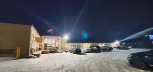 un aparcamiento cubierto de nieve frente a un motel en Belmont Inn, en Sudbury