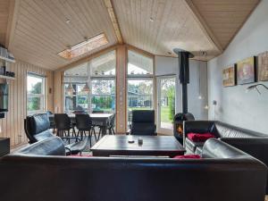 a living room with black leather furniture and a table at 8 person holiday home in R dby in Rødby