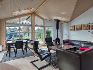 a living room with a couch and a table and chairs at 8 person holiday home in R dby in Rødby
