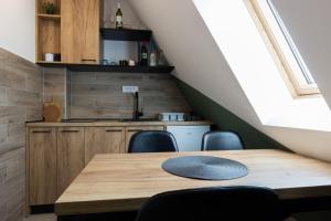 a dining room table with chairs and a kitchen at Apartman Maslacak in Divčibare