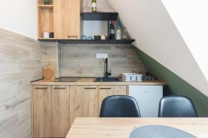 a kitchen under the stairs with a table and chairs at Apartman Maslacak in Divčibare