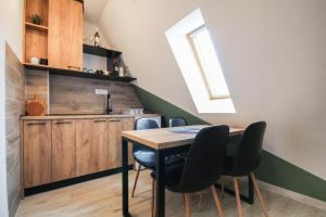 a kitchen with a table and chairs in a room at Apartman Maslacak in Divčibare