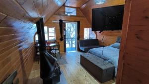 a room with a bed and a tv in a cabin at Oásis Pousada in Cambará