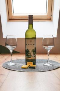a bottle of wine and two glasses on a table at Apartman Maslacak in Divčibare