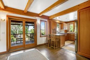 a kitchen with wooden cabinets and a table with chairs at Bainbridge Island Timber Retreat in Fort Ward