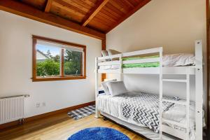 Fort Ward的住宿－Bainbridge Island Timber Retreat，一间卧室设有双层床和窗户。