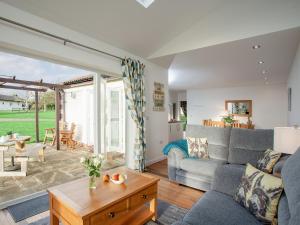 uma sala de estar com um sofá e uma mesa em Wonkey Donkey Cottage em Salcombe Regis
