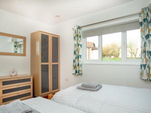 um quarto com 2 camas e uma janela em Wonkey Donkey Cottage em Salcombe Regis