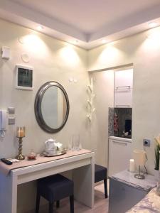 een kamer met een wastafel met stoelen en een spiegel bij Tiny Deluxe Suite in Kalamaria in Thessaloniki