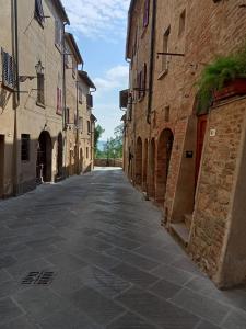 una strada vuota in un vicolo tra due edifici di Affittacamere Il Bastione 27 a Volterra