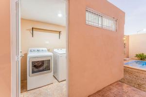 an open door to a laundry room with a washer and dryer at Casa Familiar Sian Kaan in Caucel