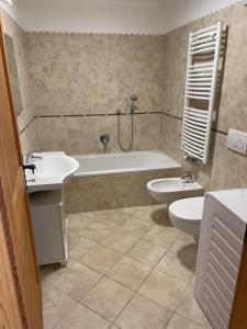 y baño con 2 lavabos, bañera y aseo. en Appartamento Verena en Dobbiaco
