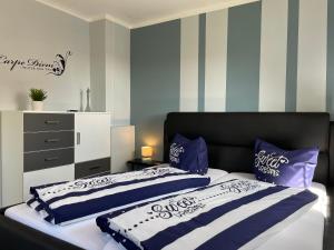 2 Betten in einem Schlafzimmer mit blauen und weißen Streifen in der Unterkunft SweetDreams - Stadtvilla von 1936 - bis 8 Pers - 150qm - 5 Schlafzimmer - 2 Bäder - Hunde willkommen in Bad Sachsa