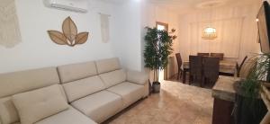 una sala de estar con un sofá blanco y una mariposa en la pared en BUNGALOW CON ENCANTO, MONTE DE MAR, en Gran Alacant