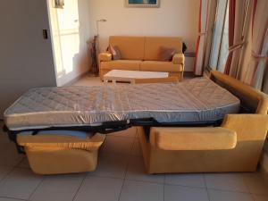 łóżko w pokoju z kanapą i stołem w obiekcie Royan accès direct à la plage w mieście Royan