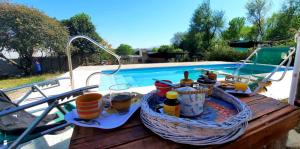 a table with bottles and baskets next to a swimming pool at La Maru in Villa Giardino