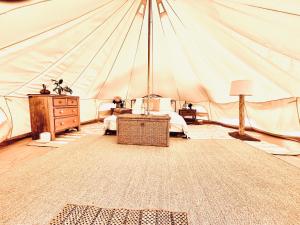 een kamer met een tent met een bed en een tafel bij Golden Point Glamping in Faraday