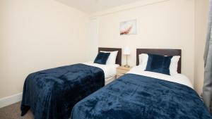 Dos camas en una habitación con azul y blanco. en Luxury Shirley Apartments close to Solent Uni and Southampton Central Train Station, en Southampton