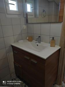 a bathroom with a sink and a mirror at Σοφίτα Καλλύνω in Thessaloniki