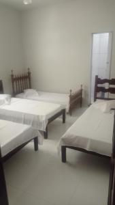 - un groupe de lits dans une chambre dans l'établissement Pousada Nova, à Montes Claros