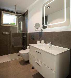 een badkamer met een wastafel, een toilet en een spiegel bij Villa Felicity in Adeje