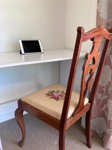 a wooden chair sitting in front of a desk with a tablet at Lookout Escape B&B in Alexandra