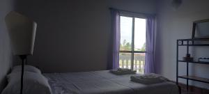 1 dormitorio con cama y ventana en Relax frente al Lago en Oliveros