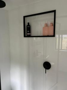 TV de pantalla plana colgada en una pared blanca en Adina Tiny House Bruny Island, en South Bruny