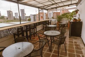 um pátio com mesas e cadeiras numa varanda em Tuki Hostel & Lounge em Pereira