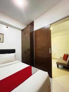 a bedroom with a bed and a sliding door at Airo Suites Makati in Manila