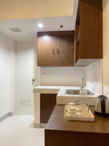 a kitchen with brown cabinets and a wooden counter top at Airo Suites Makati in Manila