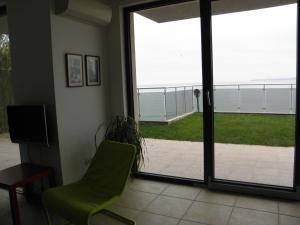 a living room with a green chair and a sliding glass door at The Beach House in Sozopol +23 photos
