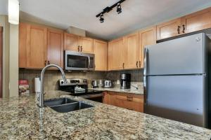 a kitchen with a sink and a refrigerator at B&B Falcon Crest Lodge 1BR 1Pullout in Canmore