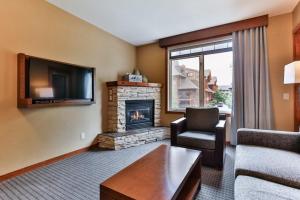 sala de estar con sofá y chimenea en B&B Falcon Crest Lodge 1BR 1Pullout en Canmore