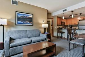 ein Wohnzimmer mit einem Sofa und einer Küche in der Unterkunft B&B Falcon Crest Lodge 1BR 1Pullout in Canmore
