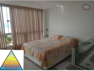a bedroom with a bed and a glass table at Felicidade in front sea in Saquarema