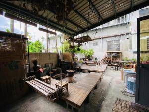 ein Zimmer mit Tischen und Bänken in einem Gebäude in der Unterkunft Luye Jamie's Guesthouse in Luye