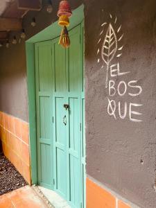 una puerta verde al lado de un edificio en Casa de Campo - Hotel Desayuno Pizza Bar en Medellín