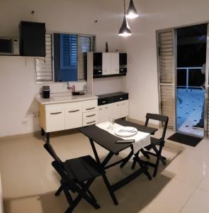 cocina con mesa, 2 sillas, mesa y mesa en Minha casa sua casa completa, en Guarulhos
