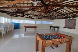 una mesa de ping pong en una habitación con sillas en Aluguel temporada em Vilas do Atlantico a 2 minutos da praia en Lauro de Freitas