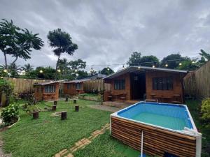 un patio trasero con piscina y una casa en Glamping Site walking distance to Majayjay Falls, en Amonoy
